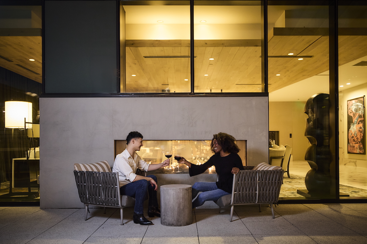 Couple having wine by outdoor fireplace